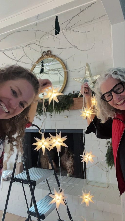 Mom and I with light up star garland decorating mantle for Christmas