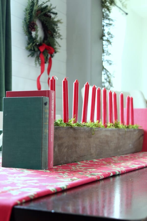 A Christmas centerpiece with moss and candles gives life to our dining room table.