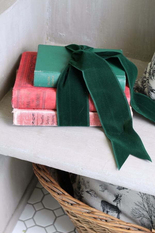 Vintage books wrapped in green velvet ribbon grace our pew for Christmas.