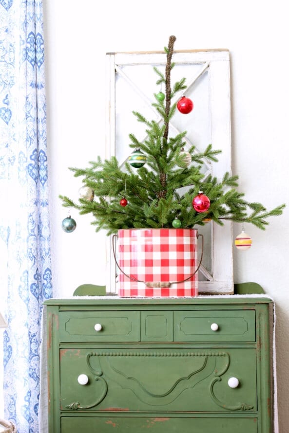 Red and white tin perfect for holding a sweet little Christmas tree with vintage ornaments.