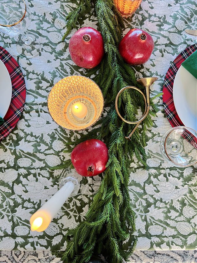 Overhead view of table set with greens and pomegranates