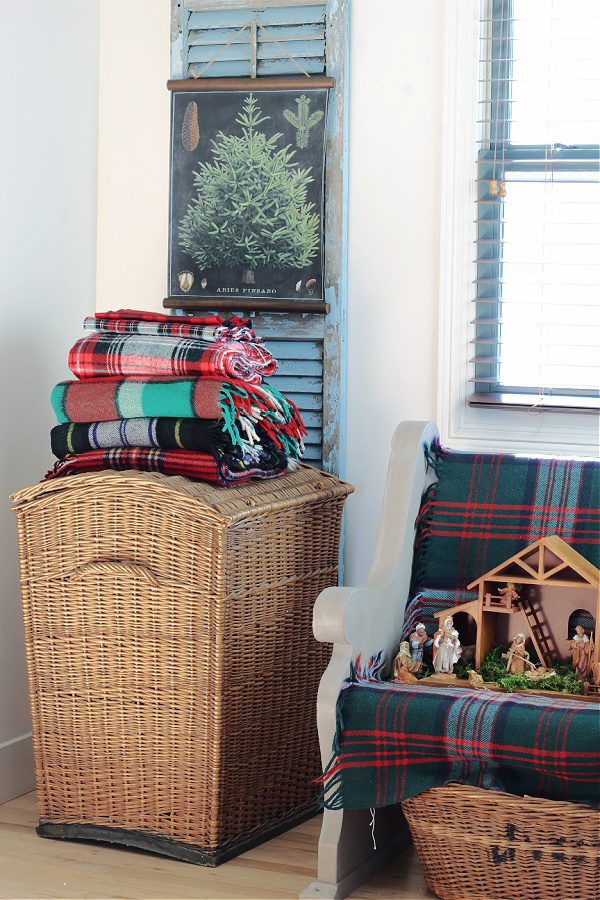Plaid blankets on top of an old basket.