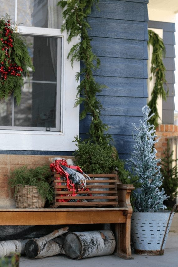 Fresh garland and pops or red and green make this porch ready for Christmas!