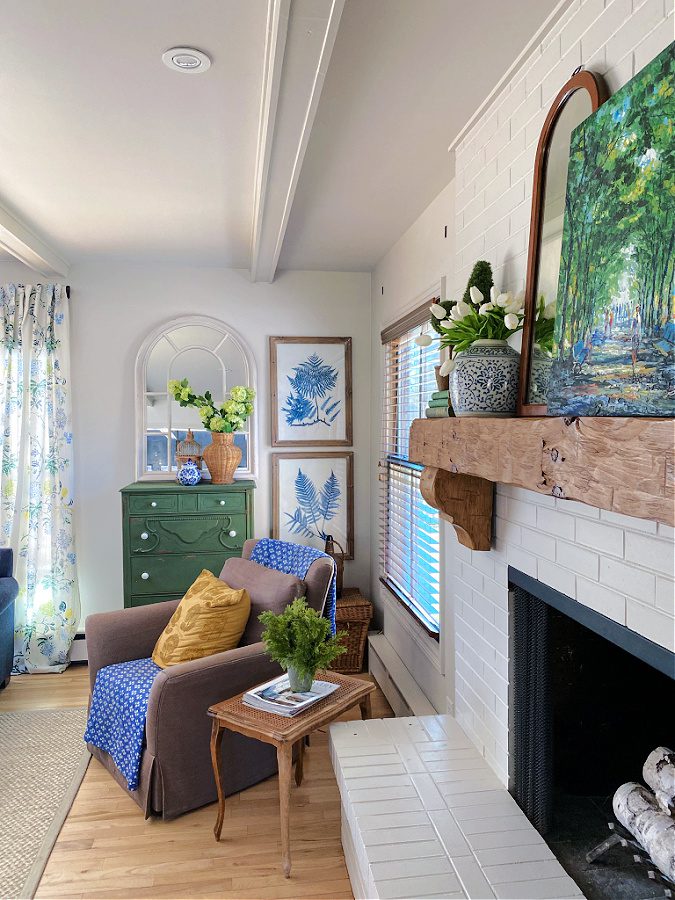 Family room with painted green dresser and cozy chair with yellow pillow.