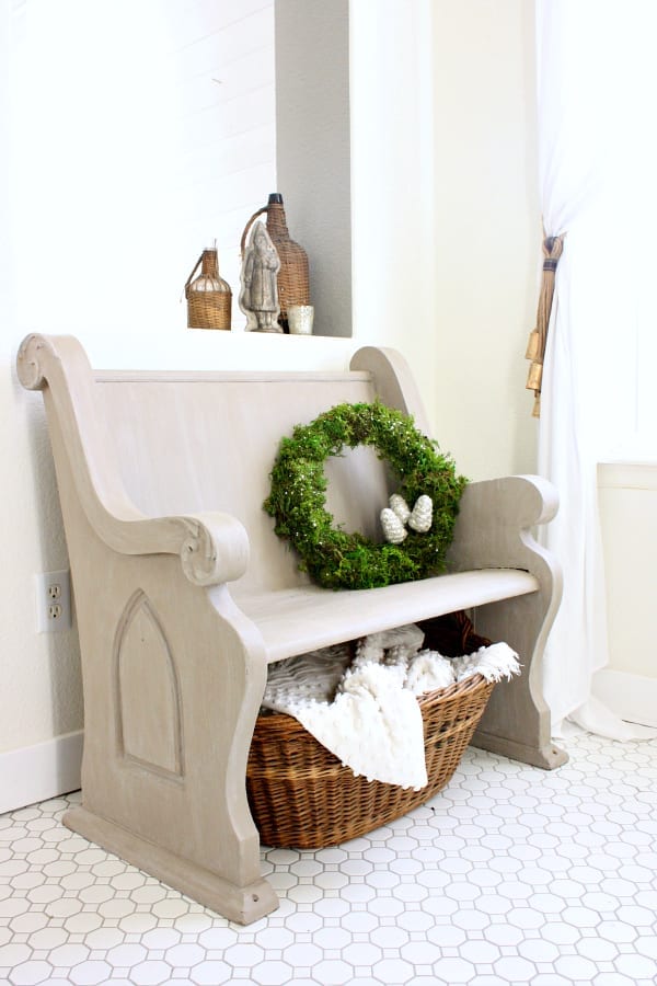 THis DIY moss and glitter wreath looks lovley just setting on an entryway bench.