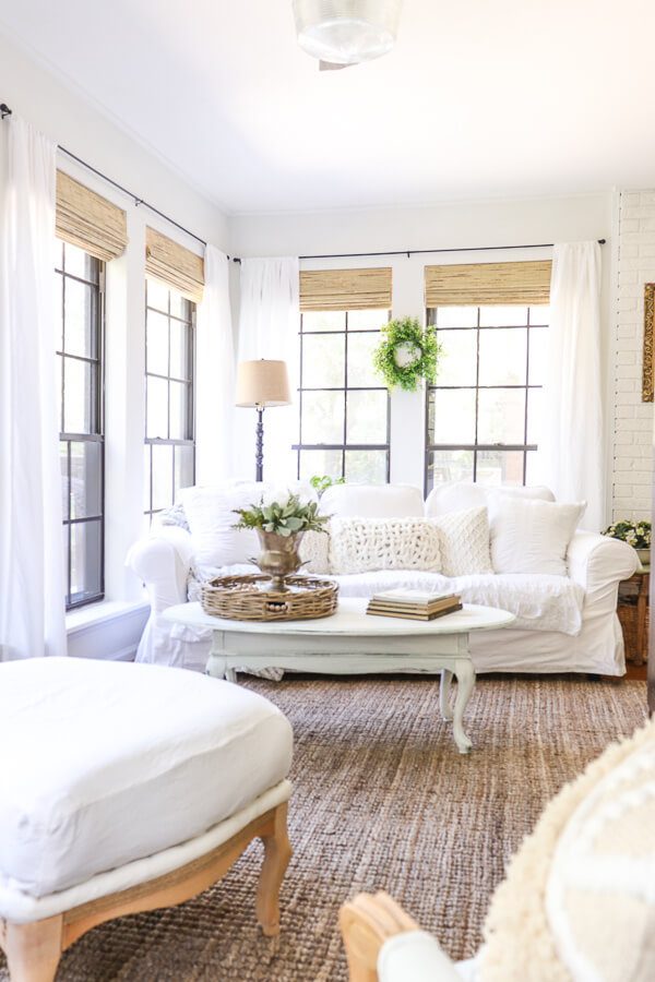 Welcome Home Saturday: Farmhouse Blinds and Updated Trim | Welcome Home Saturday by popular Alabama lifestyle blog, She Gave It A Go: image of a living room with farmhouse blinds, natural woven area rug, white couch, white coffee table, white drapes, and white armchairs. 