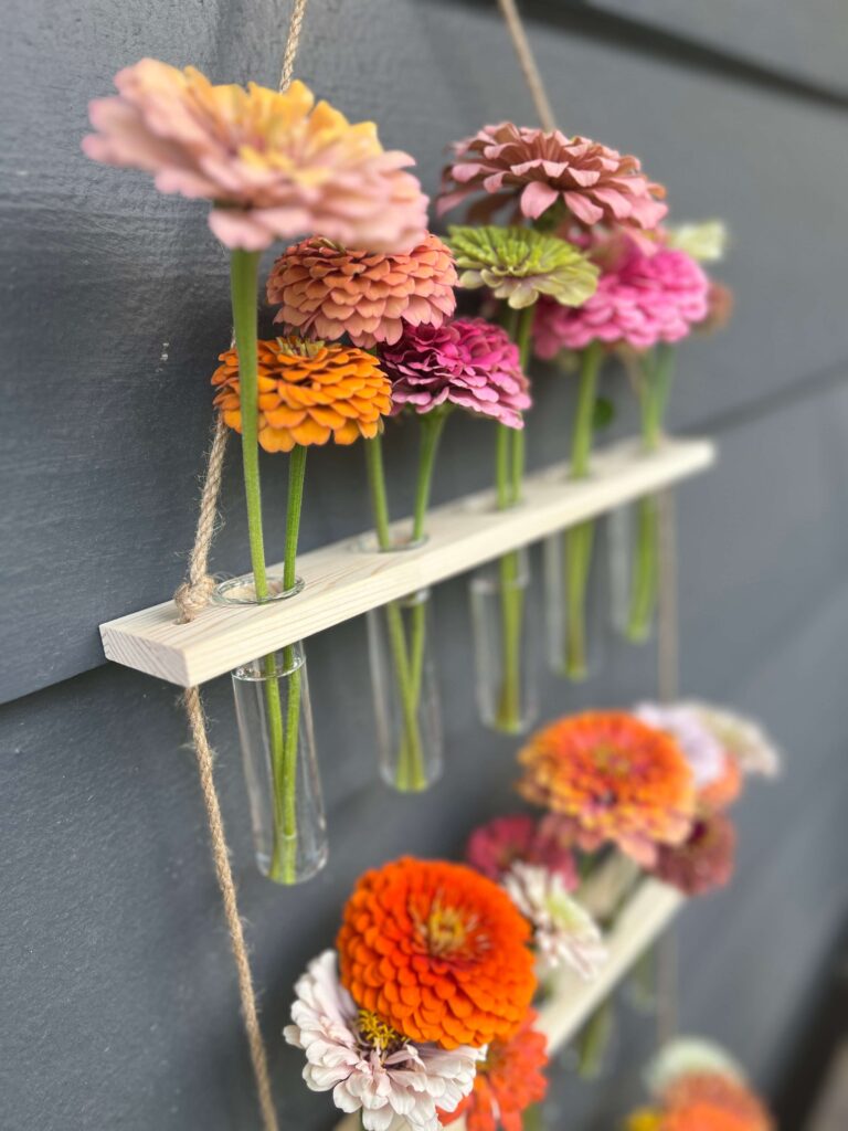 hanging wall vase close up with zinnias
