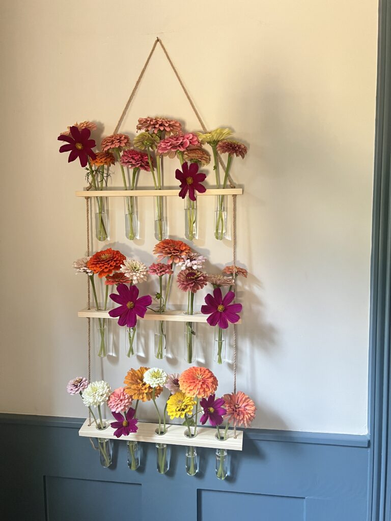 Hanging wall vase in entry with zinnias