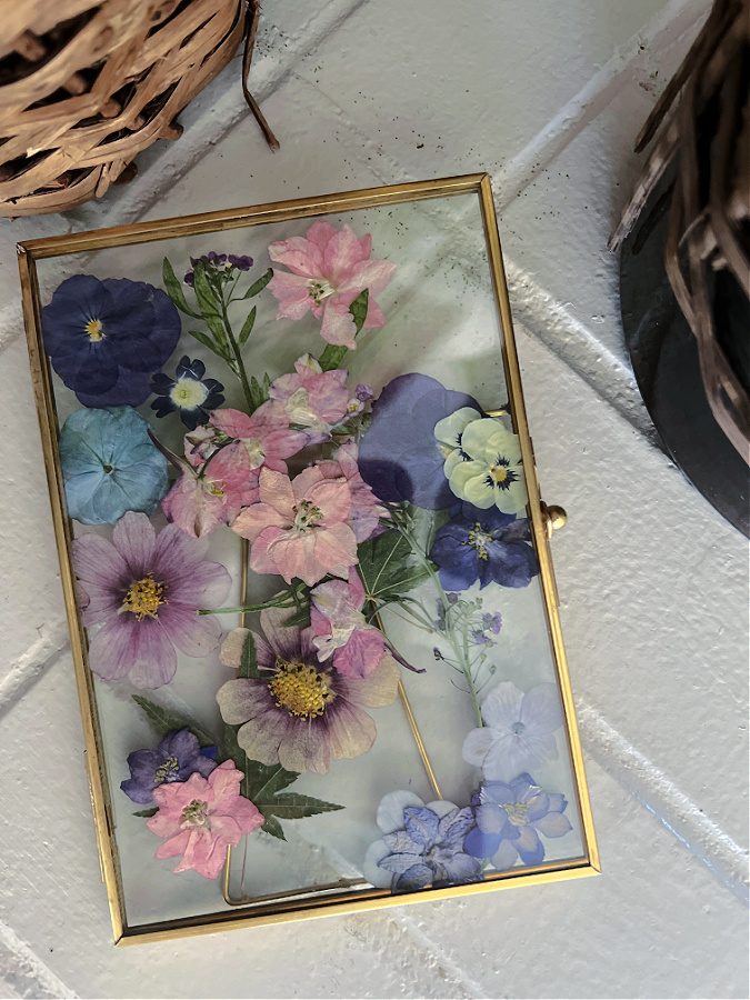 Pressed flowers inside a gold frame ready to be displayed.