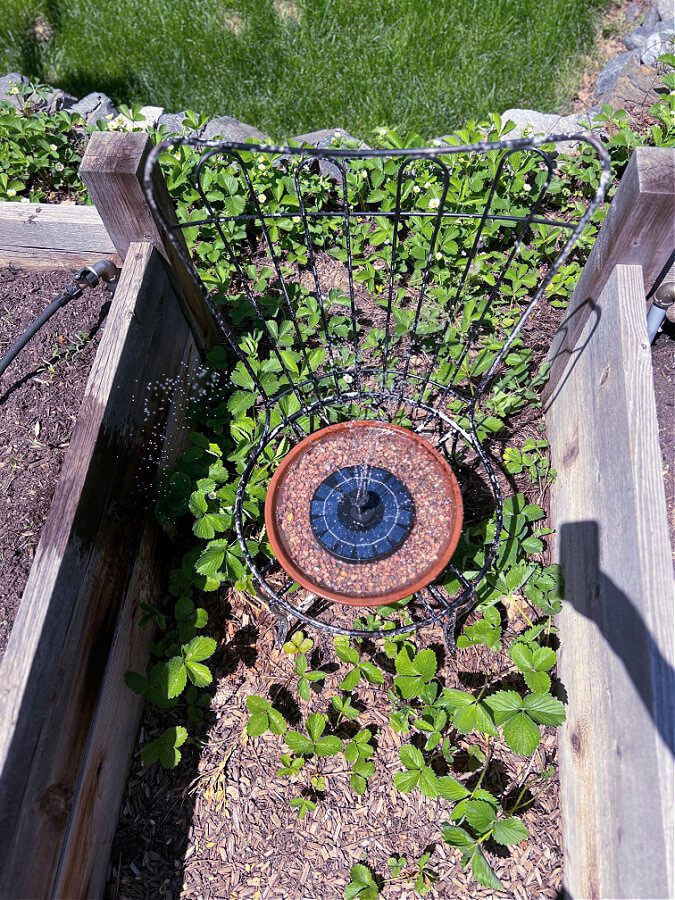 Overhead of solar fountain on metal chair