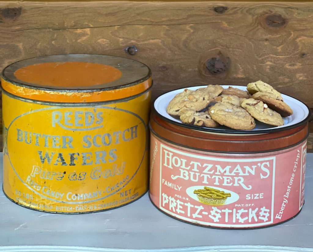Welcome Home Saturday: Pretzel Sea Salt Cookies With Chocolate & Butterscotch Chips | Welcome Home Saturday by popular Alabama lifestyle blog, She Gave It A Go: image of a plate of cookies on a white ceramic plate resting on top of a vintage Holtzman's butter tin. 