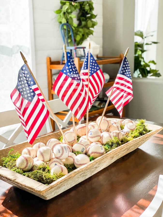 A fun and easy baseball centerpiece! | Welcome Home Saturday by popular Alabama lifestyle blog, She Gave It A Go: image of a baseball centerpiece with baseballs, American flags, and moss. 