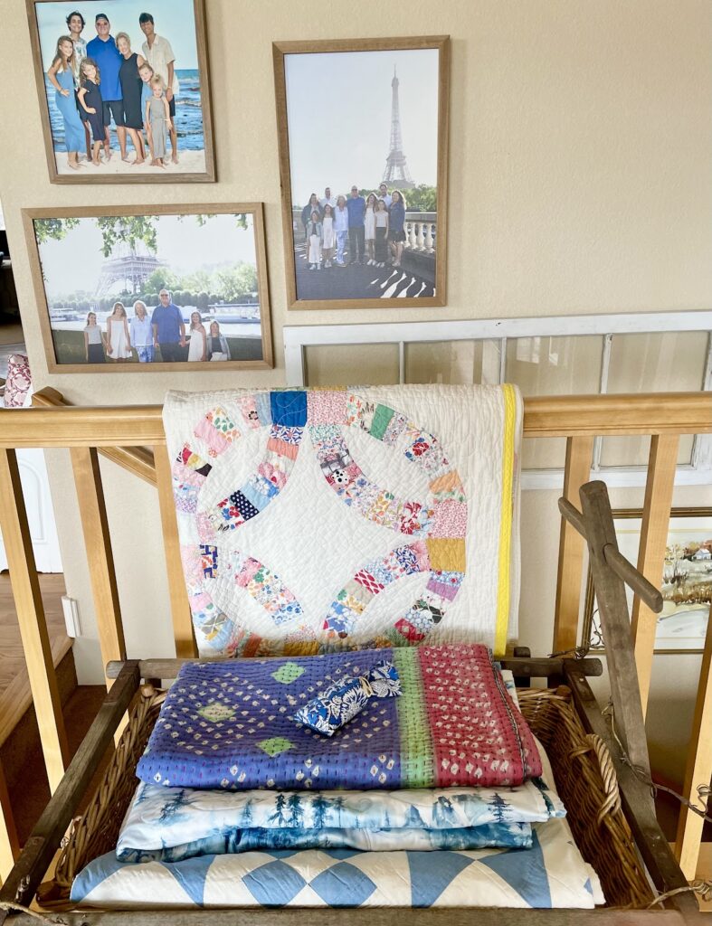 colorful quilts hung over stair banister