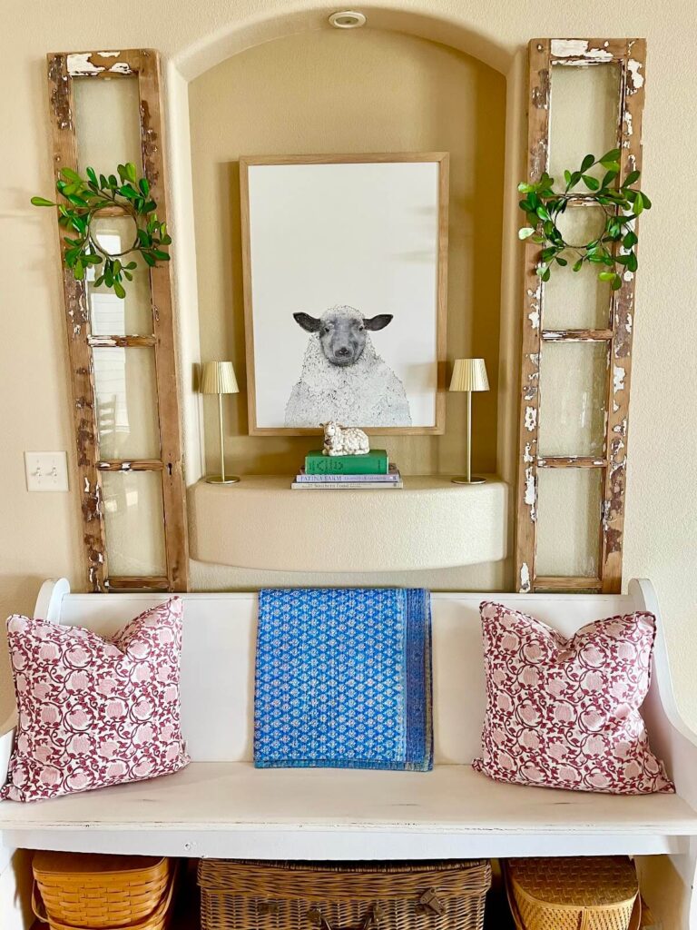 Church pew with pillows and lamb picture hung above in alcove