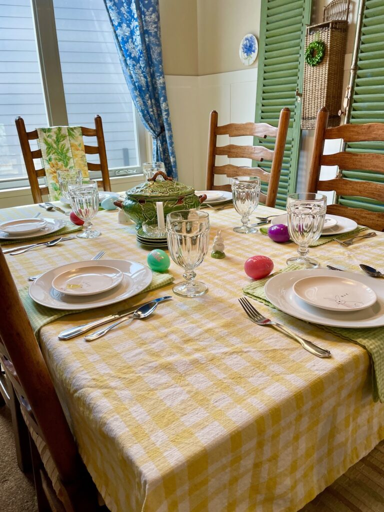 Easter table with yellow tablecloth, plates, eggs