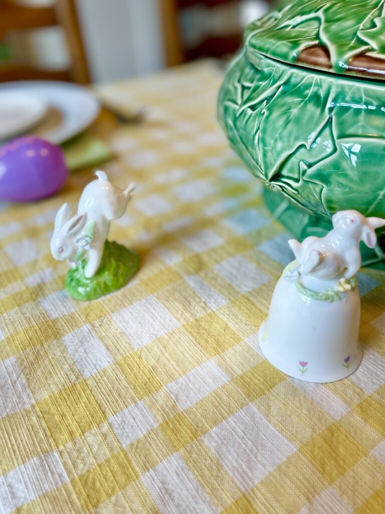 porcelain bunny bells on yellow tablecloth
