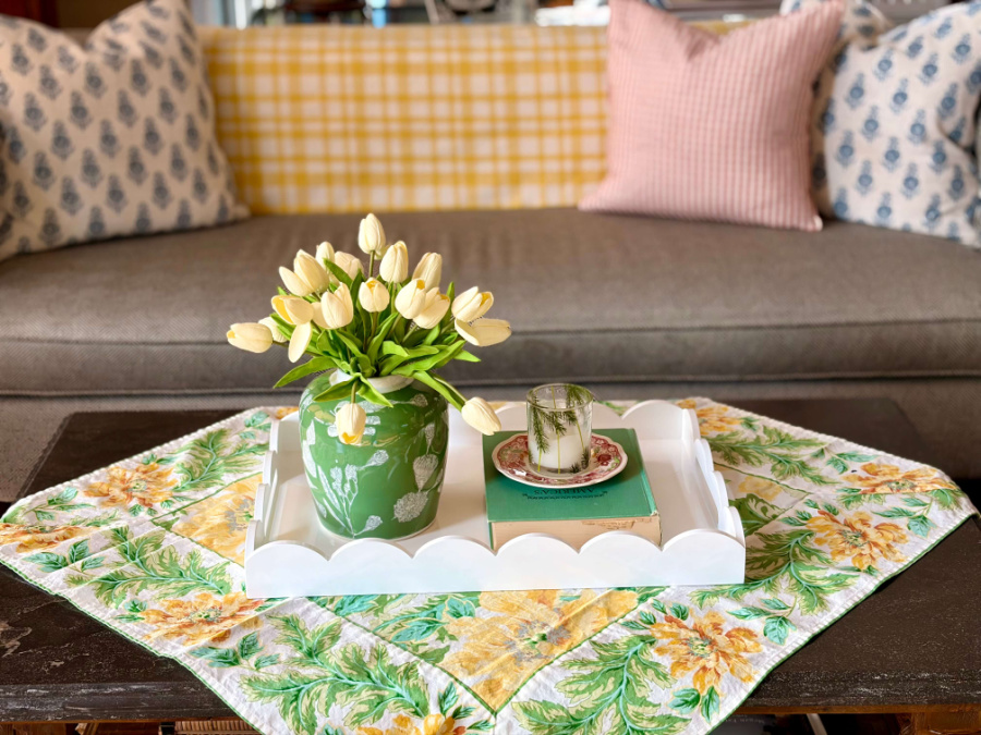 faux tulips in green vase on yellow tablecloth