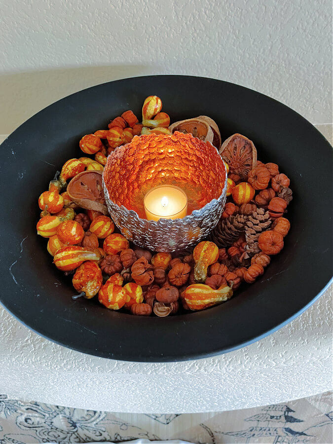 mini gourds and candle fill black bowl