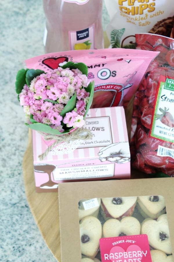 Mini pink flowers in metal containers make this Valentine's Dessert board extra special!