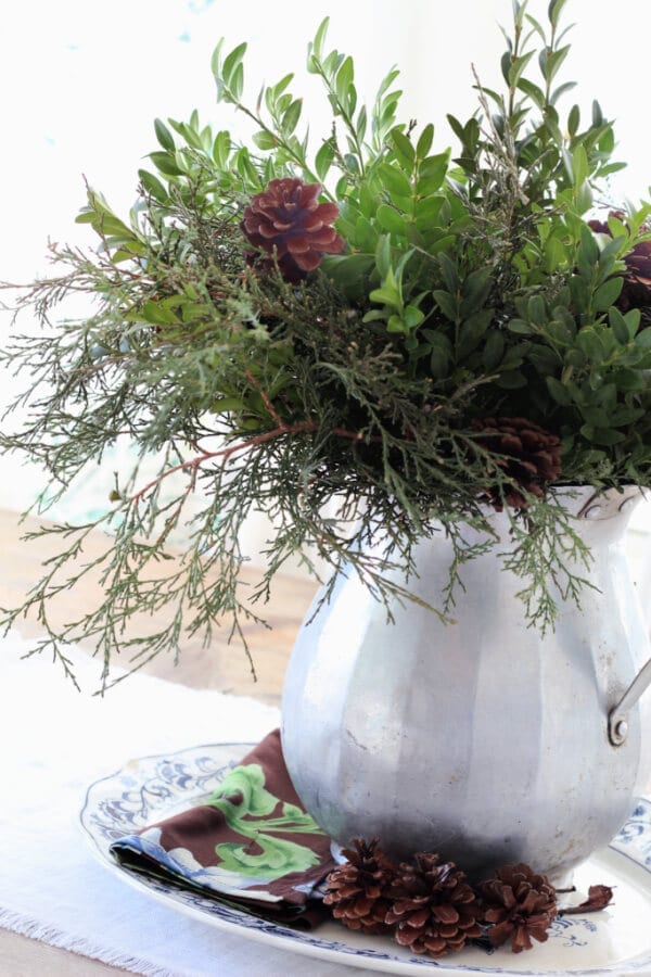 A simple winter centerpieces with foraged greenery and pine cones.