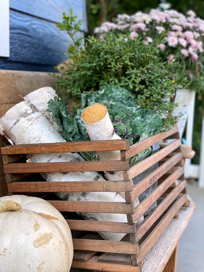 Adding vintage crates to your porch full of collected treasures adds a touch of charm to your space.