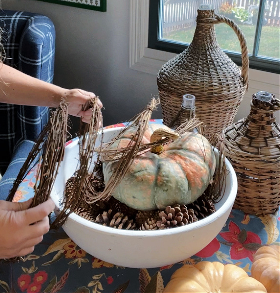 Winding the grapevine garland around the pumpkin centerpiece