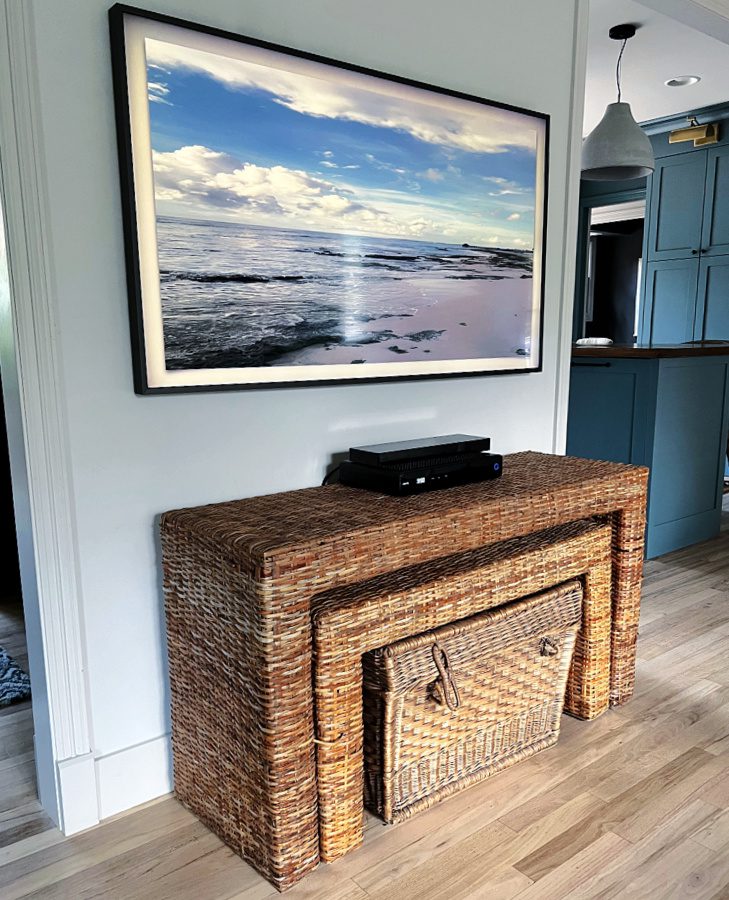 Wicker console table under frame tv add a lovely coastal touch.