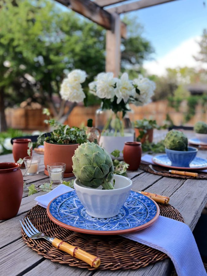 An outdoor table setting featuring blues and terracotta accents.