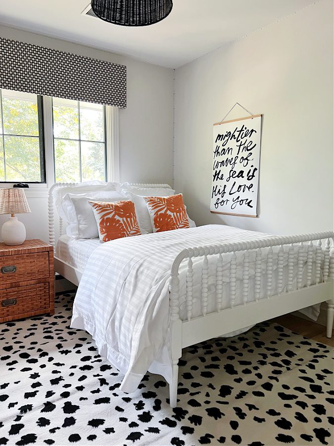 White bed with orange pillows