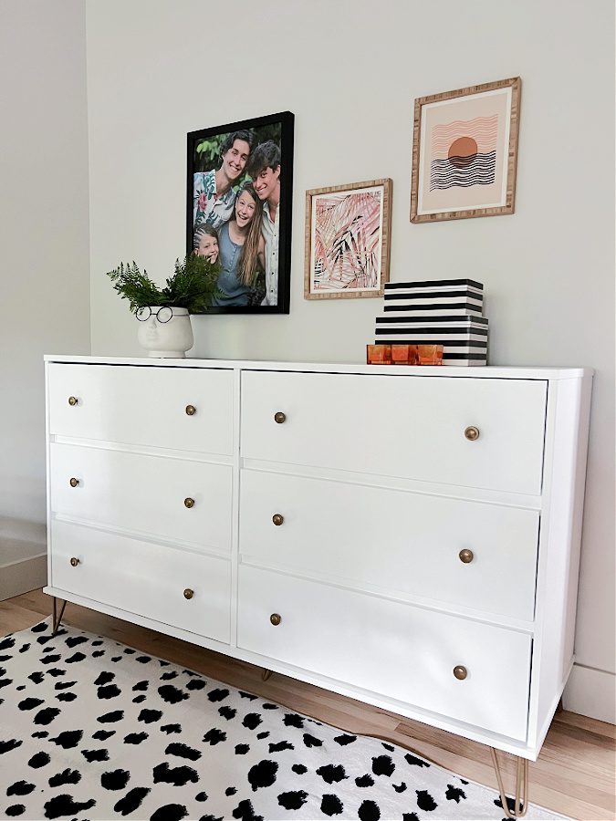 White dresser styled with decor and patterned rug in black and white