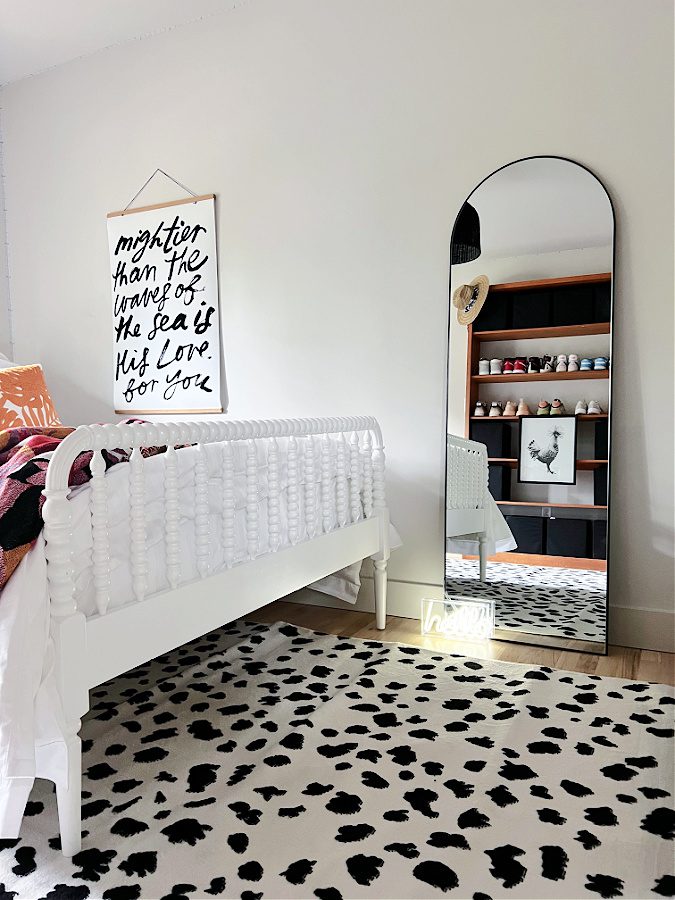 End of beachy teen bed with mirror reflecting other side of room