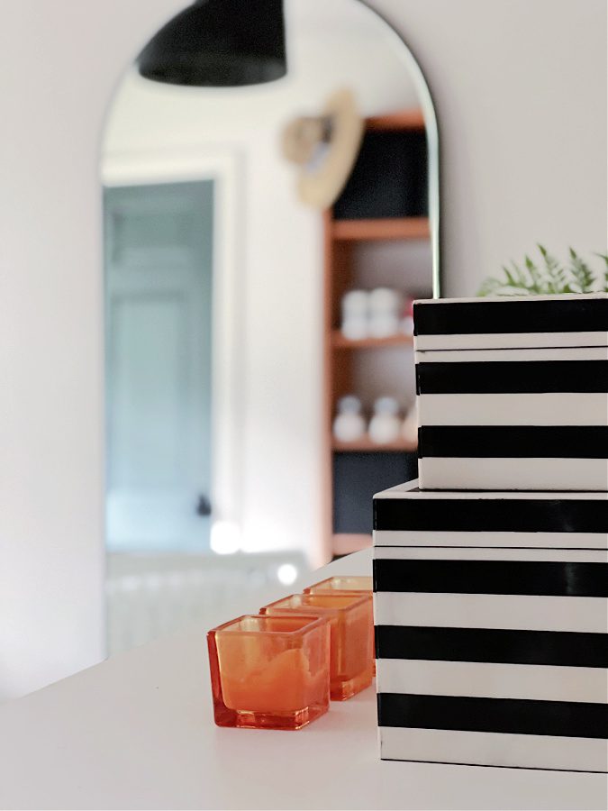 Black and white striped boxes, and orange candles in a beachy teen girl bedroom