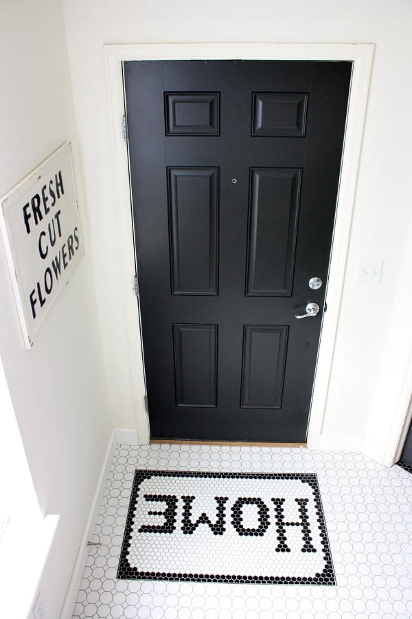 A black interior door with white trim and white walls