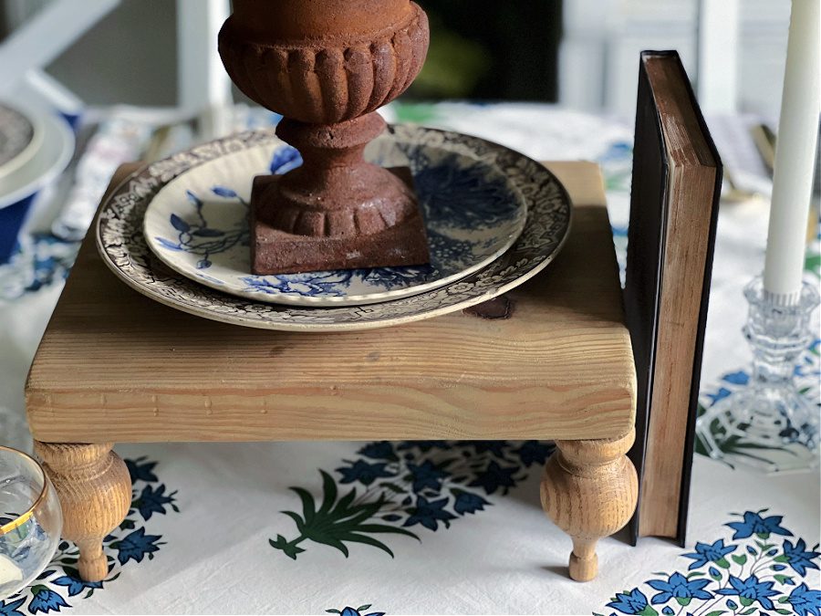 Wooden pedestal, book and plates on table