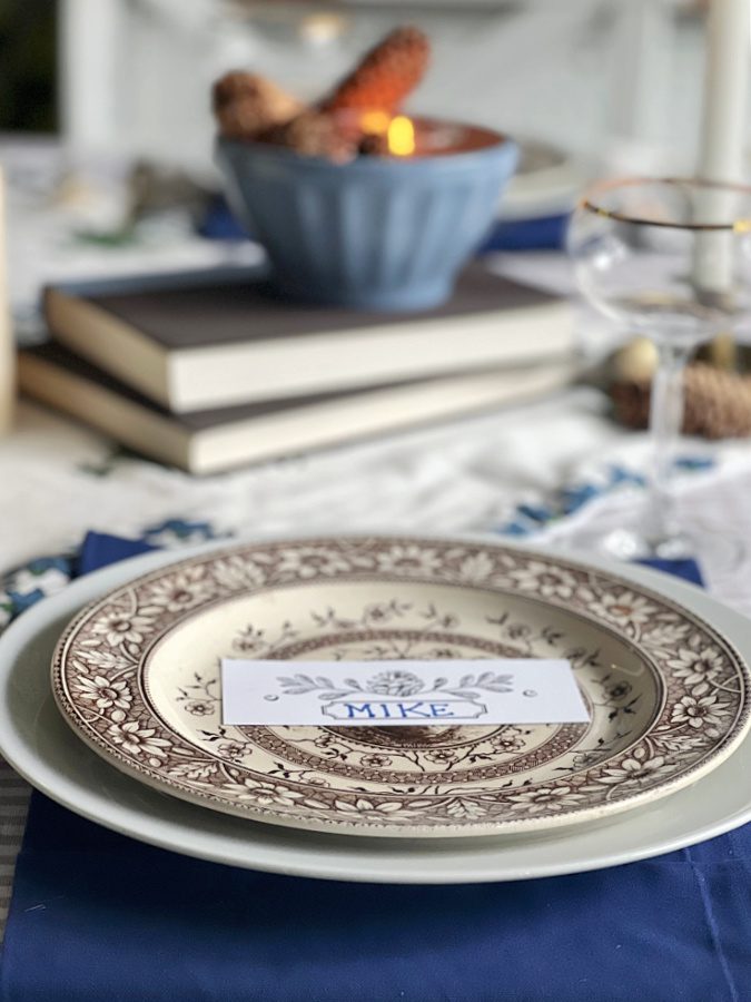 Brown transferware plate layered on white plate with place card