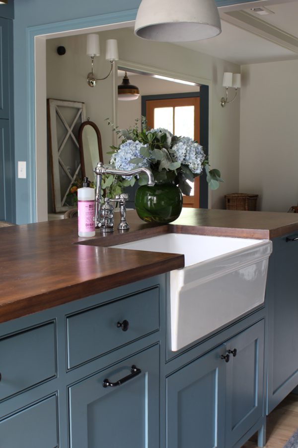 Butcher block counter tops, farm sink and gorgeous blue cabinets.