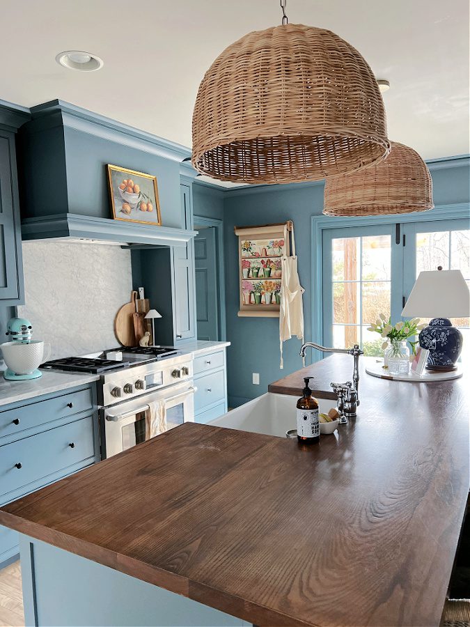 View of wicker pendants and blue kitchen decorated for our spring home tour.