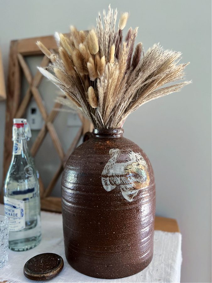 Brown pottery jug with dried fall grasses