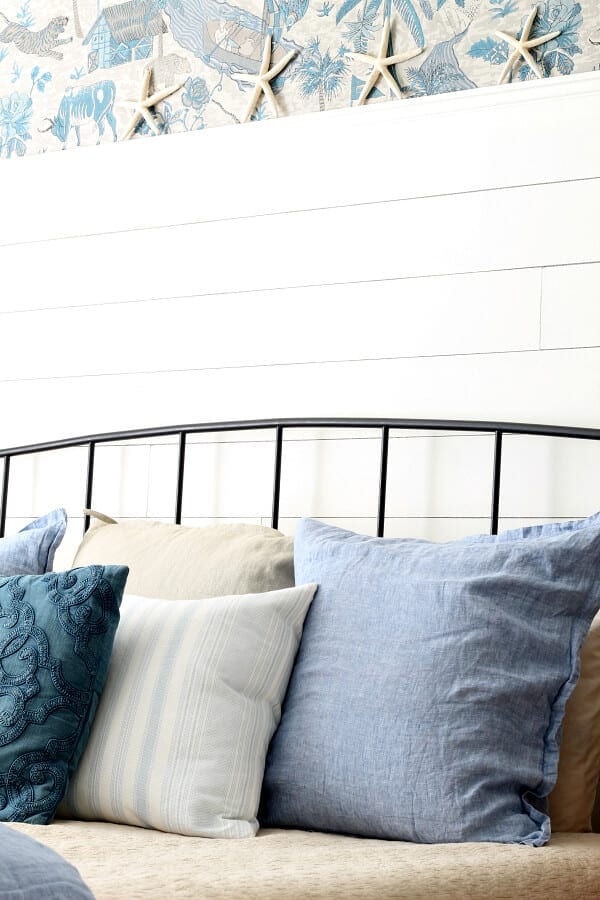 Starfish, wallpaper and calming blues make this coastal cottage master bedroom cozy and casual.