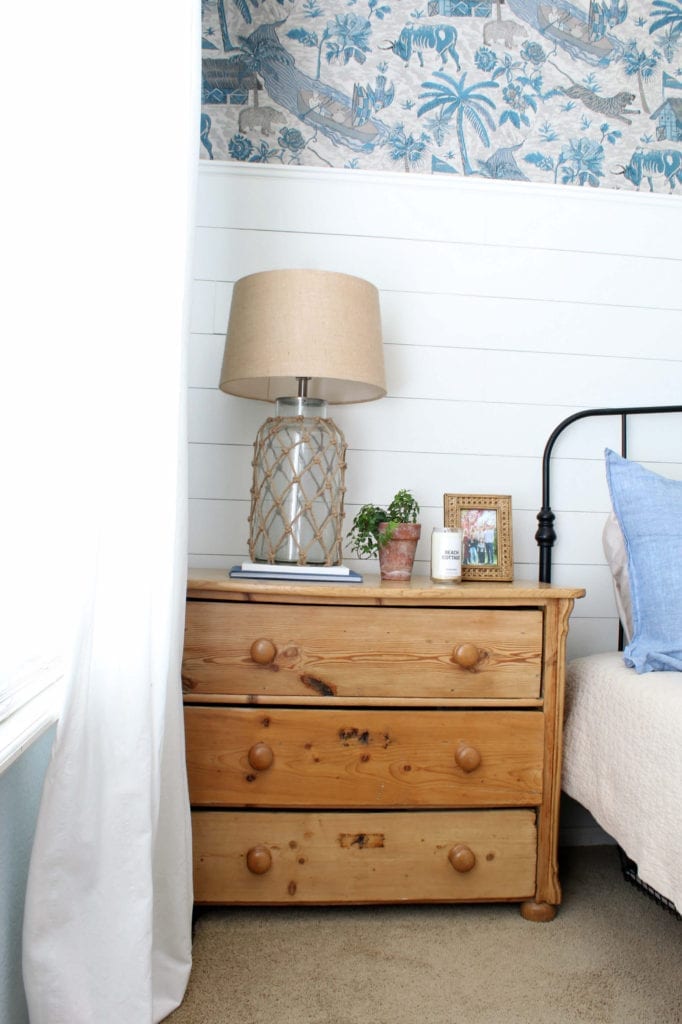 A vintage dresser with a coastal vignette makes this room feel collected and cozy.