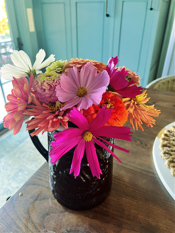 old brown pitcher with colorful flowers