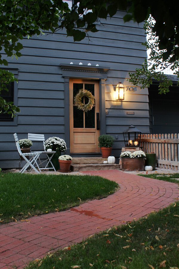 A brick path leads you to our wood door and front steps decorated for Fall.