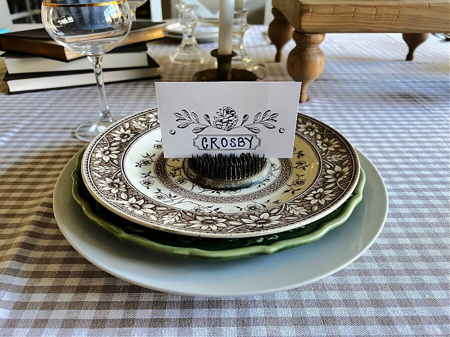 place card propped in vintage flower frog on plate