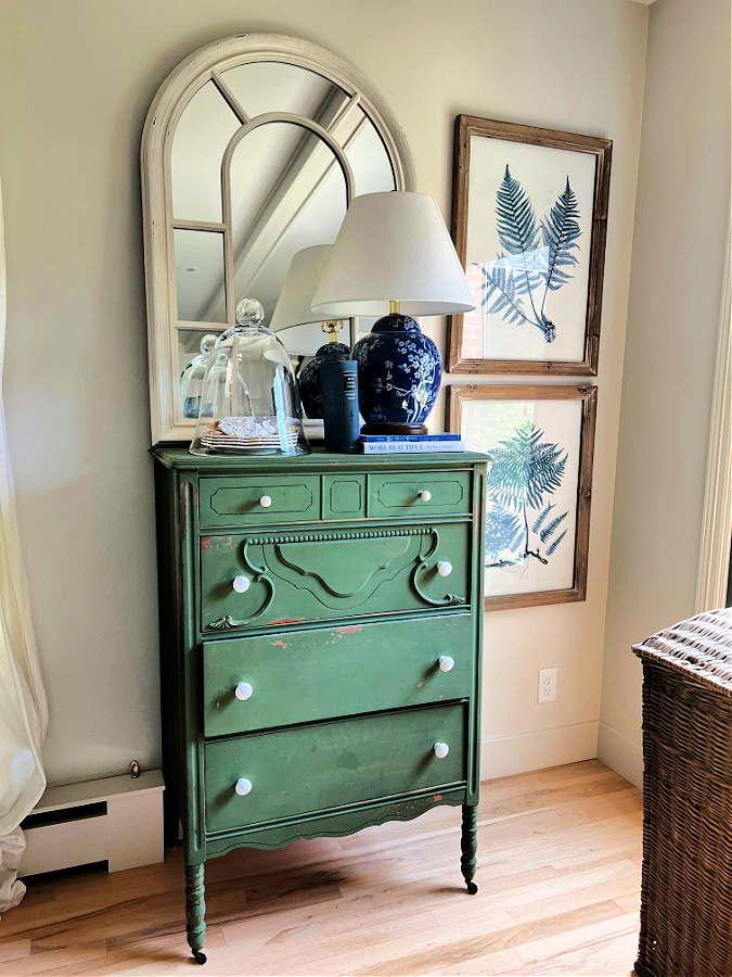 Green dresser with summer vignette including glass cloche