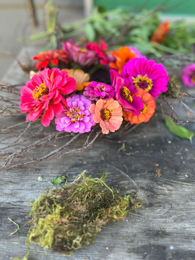 Adding moss to zinnia wreath