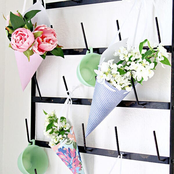 May Day baskets on a mug rack full of flowers.