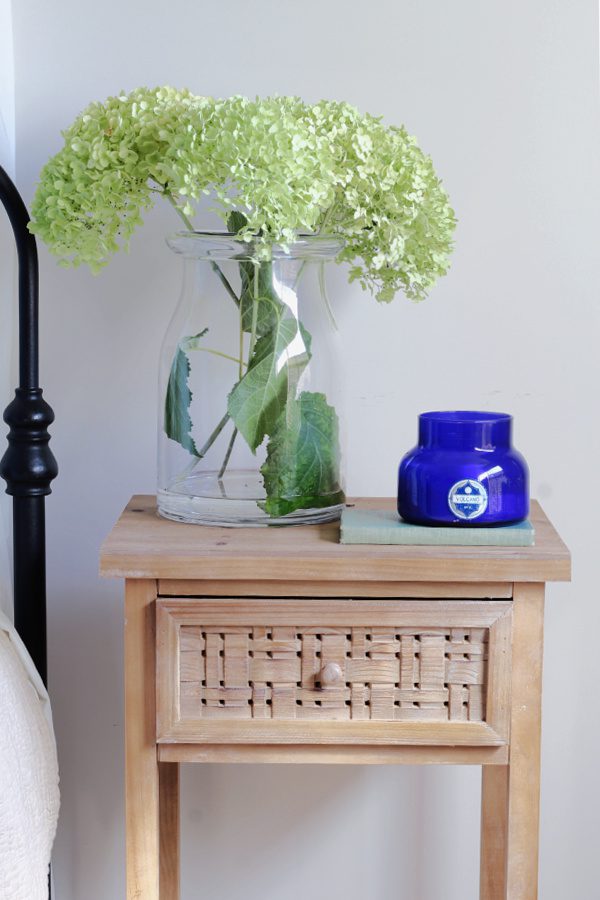 Dried hydrangeas, a volcano candle and wood nightstand.