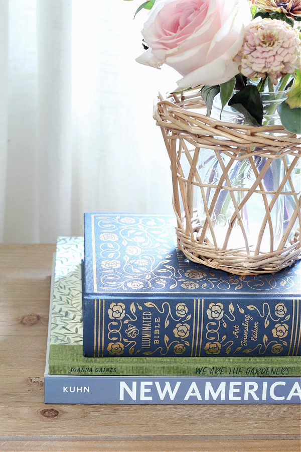 A stack of books and fresh flowers bring life to our master bedroom.