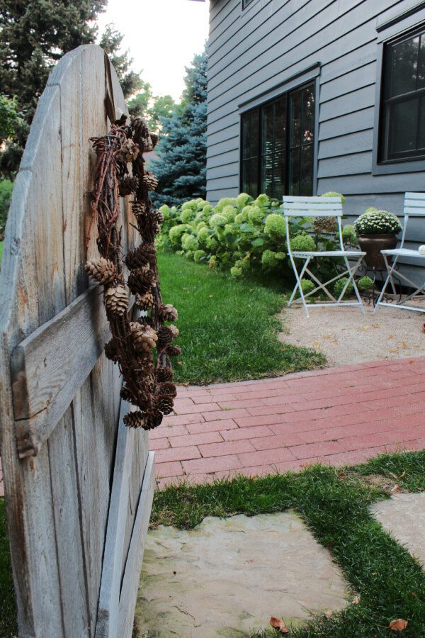 pinecone wreaths, gates, hydrangeas and bistro chairs say Fall is near.