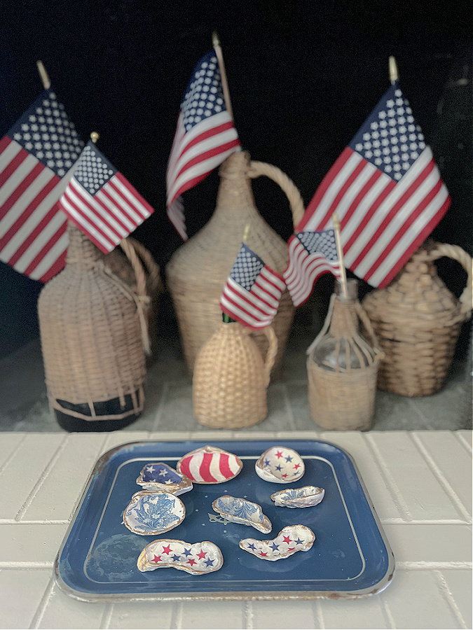 flags in wicker demi johns with sea shells in front